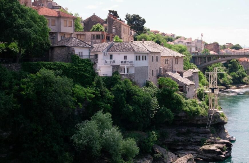 trees and houses by river in mostar in bosnia and herzegovina